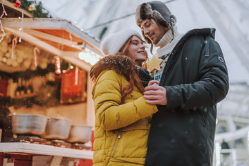 Happy loving couple walking near Christmas market