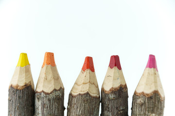 Tips of five rustic wooden color pencils, with white background