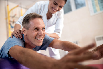 Obraz premium Happy mature patient is doing rehab exercises