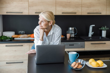 Beautiful adult woman is looking away thoughtfully