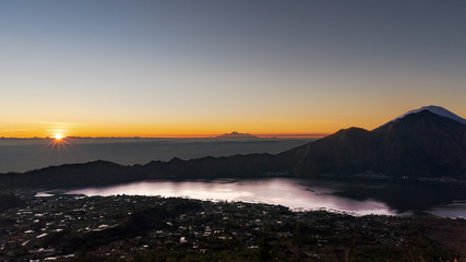 Obraz premium Stunning Sunrise from the top of Mt. Batur, Bali, Indonesia. In the right, across lake Batur, Mt Abang and Mt Agung. Central in the background, some peaks of Lombok.