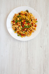 View from above, homemade southwestern egg scramble on a white plate on a white wooden background. Flat lay, top view, from above. Copy space.
