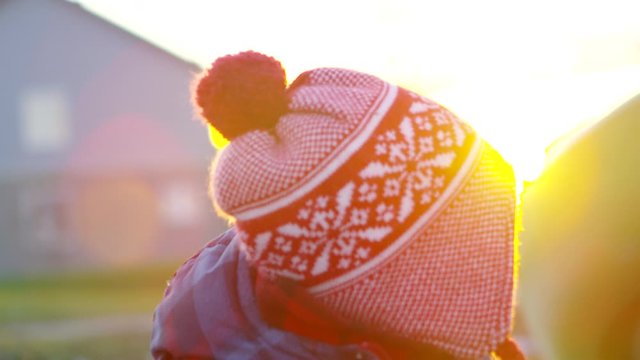 Toddler bot swings around from mothers arms - outdoors playing in late fall early winter