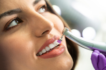 Closeup young woman getting her teeth polished