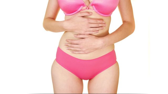 Close up zoom in towards woman in pink underwear holding stomach