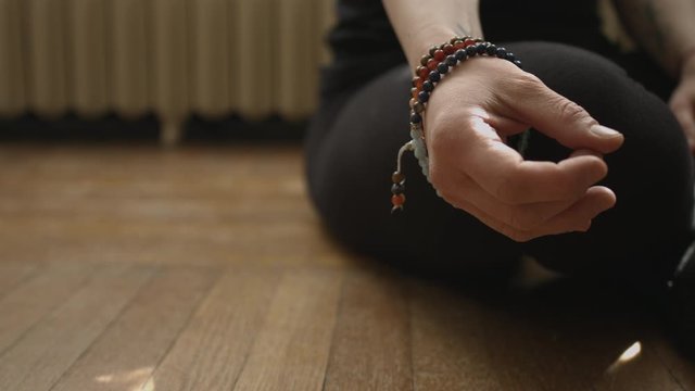 Slider shot of a woman's hand in a meditative prayer gesture for yoga in 4K UHD