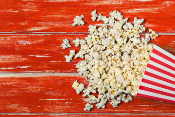 Popcorn bucket on red wooden background with copy space. Top view. Flat lay