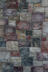 Colorful modern marble-like tile wall texture with blocks in varying hues of rose red, blue, and gray