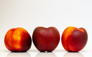 Three nectarines on a white background