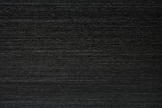 Close up industrial background of fractally scratched direct horizontal lines to black metal/stainless steel surface. Creative detail macro