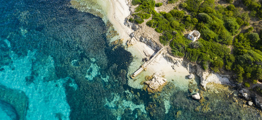 View from above, stunning aerial view of an abandoned harbour bathed by a turquoise water. Maddalena Archipelago National Park, Sardinia, Italy.