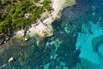 View from above, stunning aerial view of an abandoned harbour bathed by a turquoise water. Maddalena Archipelago National Park, Sardinia, Italy.