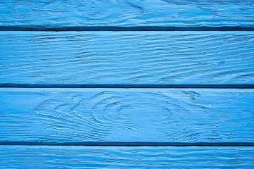 Wooden background texture. Creatively painted intense blue boards.