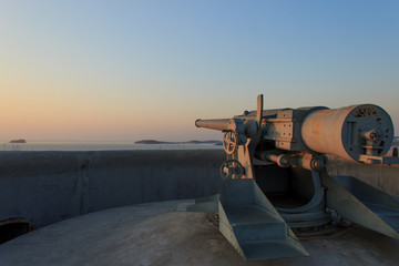 Fototapeta na wymiar A gun on the Novosiltsevsky battery of the Russian island in Vladivostok at dawn.