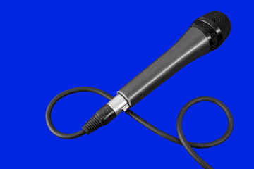 gray professional microphone with black and dark cable on a blue background