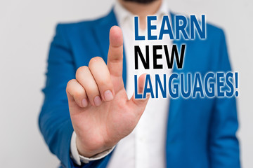 Word writing text Learn New Languages. Business photo showcasing developing ability to communicate in foreign lang Businessman in blue suite and white shirt pointing with finger in empty space