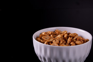 bowl with peanuts and black background