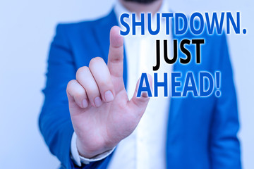 Word writing text Shutdown Just Ahead. Business photo showcasing closing factory business either short time or forever Businessman in blue suite and white shirt pointing with finger in empty space