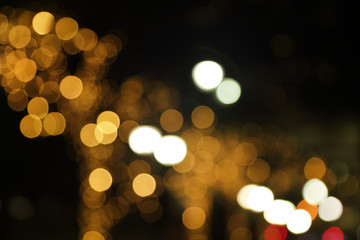 Blurry background image of defocused golden color abstract city street lights at night
