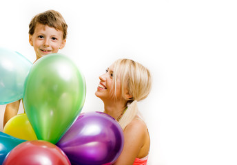 Fototapeta na wymiar pretty real family with color balloons on white background, blond woman with little boy at birthday party bright smiling happy mother