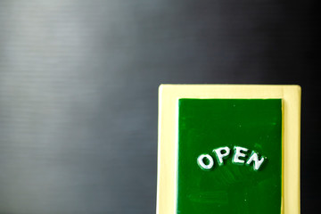 黒バックと OPENの文字の看板とコピースペース