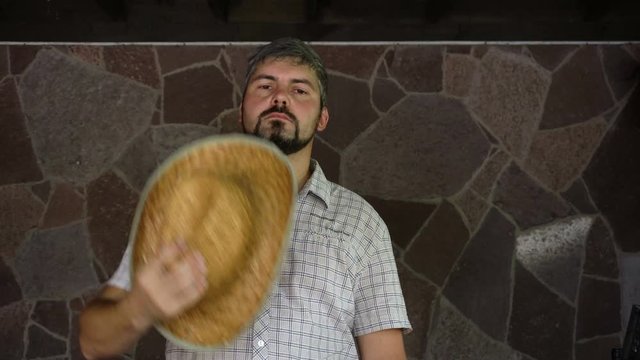 A man with a straw hat is sad. Mourns for the departed. On the face is a beard. Portrait to the waist. 4K video