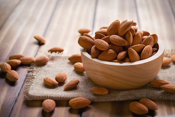 almonds in bowl wood on dark table background