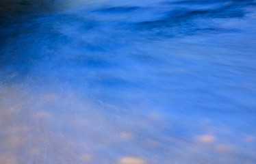 background or abstract of river water rushing over stones creating a blurred effect