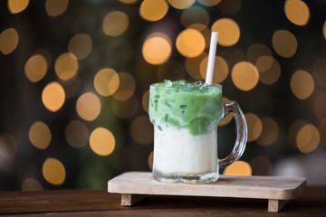 Glass of iced green tea on wooden table.