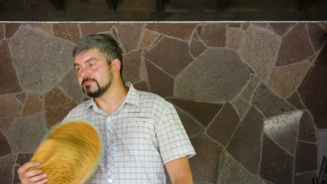 A man in a plaid shirt. Holds and removes a straw hat. Average age. Funny look. The farm. Country life. Portrait to the waist. 4K video