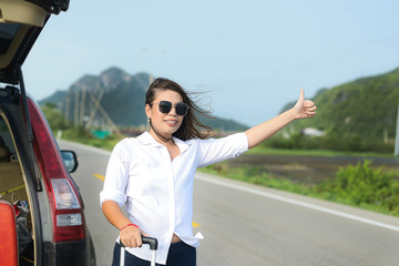 Asian woman hitchhiking after her car having problem, lifestyle concept.