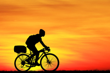 Obraz na płótnie Canvas Silhouette Cycling on blurry sunrise sky background.