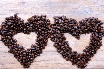 coffee beans in shape of heart on wooden background