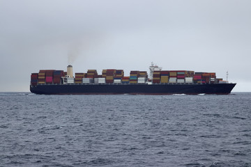 Container cargo ship moving in the ocean.