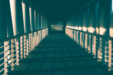 empty walkway of overpass for pedestrian with light and shadow. toned photo