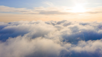Obraz premium Aerial view White clouds in blue sky. Top view. View from drone. Aerial bird's eye view. Aerial top view cloudscape. Texture of clouds. View from above. Sunrise or sunset over clouds