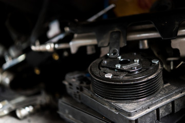 Fototapeta na wymiar Disassembled car dirty engine and pulley at garage