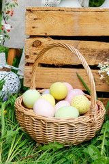 Wicker basket with Easter eggs in the garden.