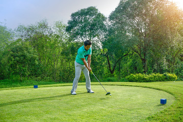Fototapeta premium Blurred golfer playing golf in beautiful golf course in the evening golf course with sunshine in thailand