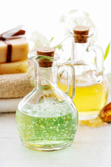 Glass bottles with liquid soap and other spa cosmetics on the table.
