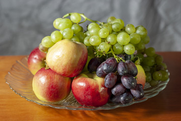 autumn still life red apples and ripe grapes of different varieties on a dish