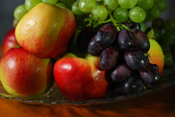 autumn still life red apples and ripe grapes of different varieties on a dish