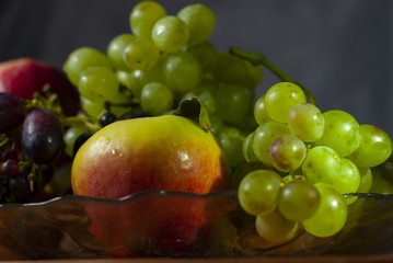 autumn still life red apples and ripe grapes of different varieties on a dish