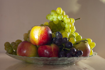 autumn still life red apples and ripe grapes of different varieties on a dish