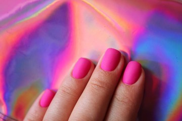 Female hands manicure closeup view on pink fluffy blanket background. Effects of nail coloring. Manicure salon banner concept