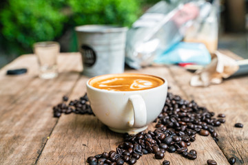 Latte art coffee in white cup with roast bean