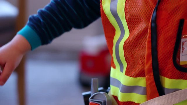 Toddler boy dressing up in construction worker costume  over pyjamas- close up