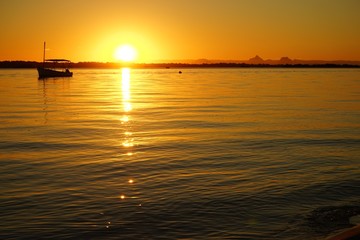 sun setting over calm water