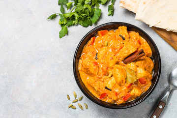 Chicken tikka masala with rice on black top view.