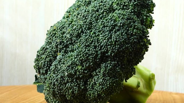 Shooting of broccoli in the movement. Cuttig board.
